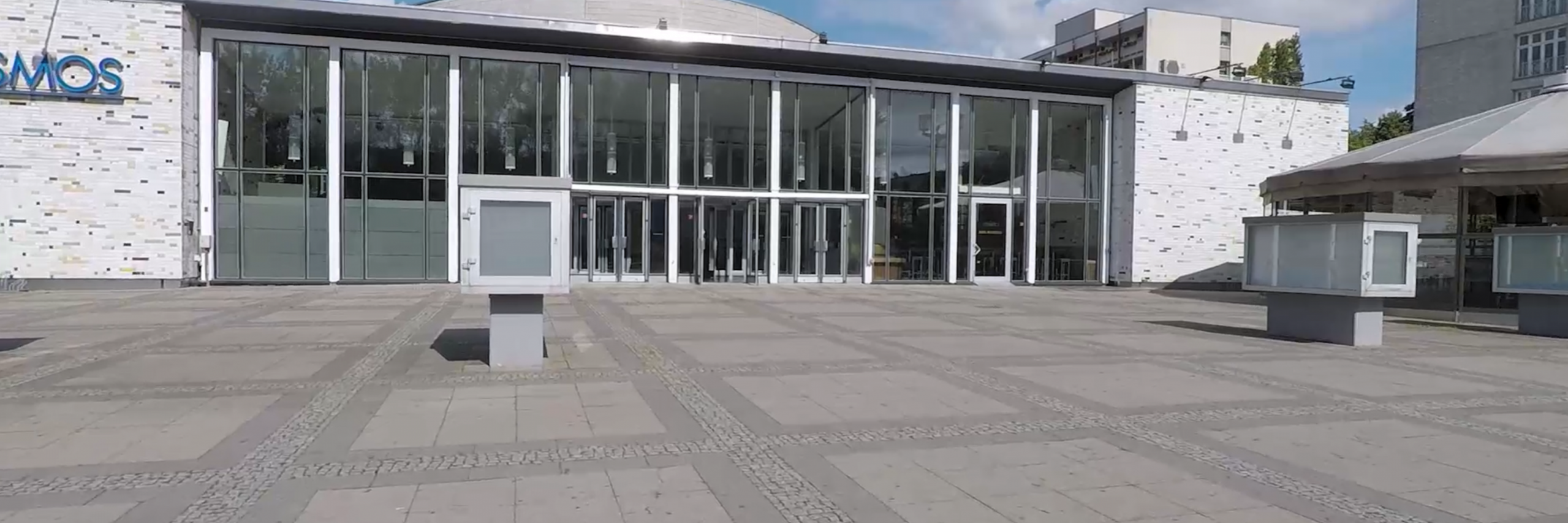 Das KOSMOS Berlin Frontansicht mit großem dazugehörigen Platz und der Outdoorarea.