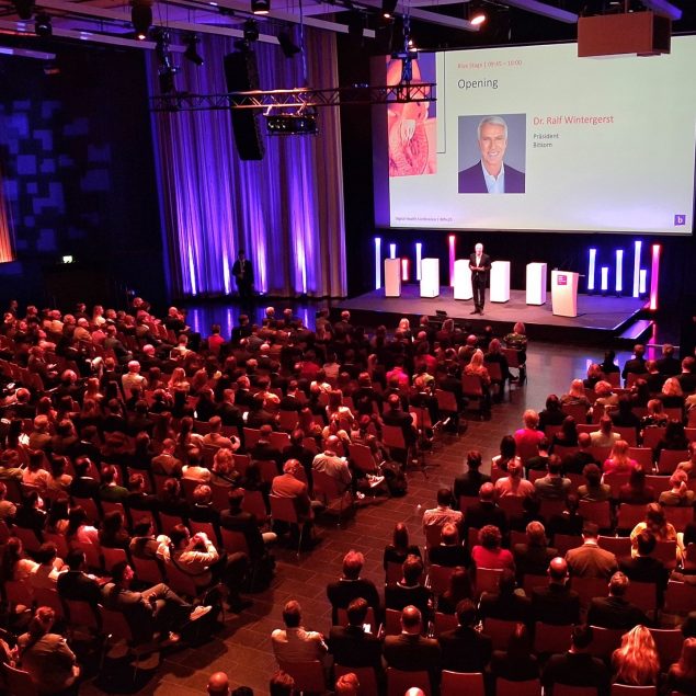 Der Hauptsaal mit Reihenbestuhlung und Ambientebeleuchtung.